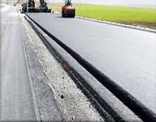 Newly paved highway with road construction machinery